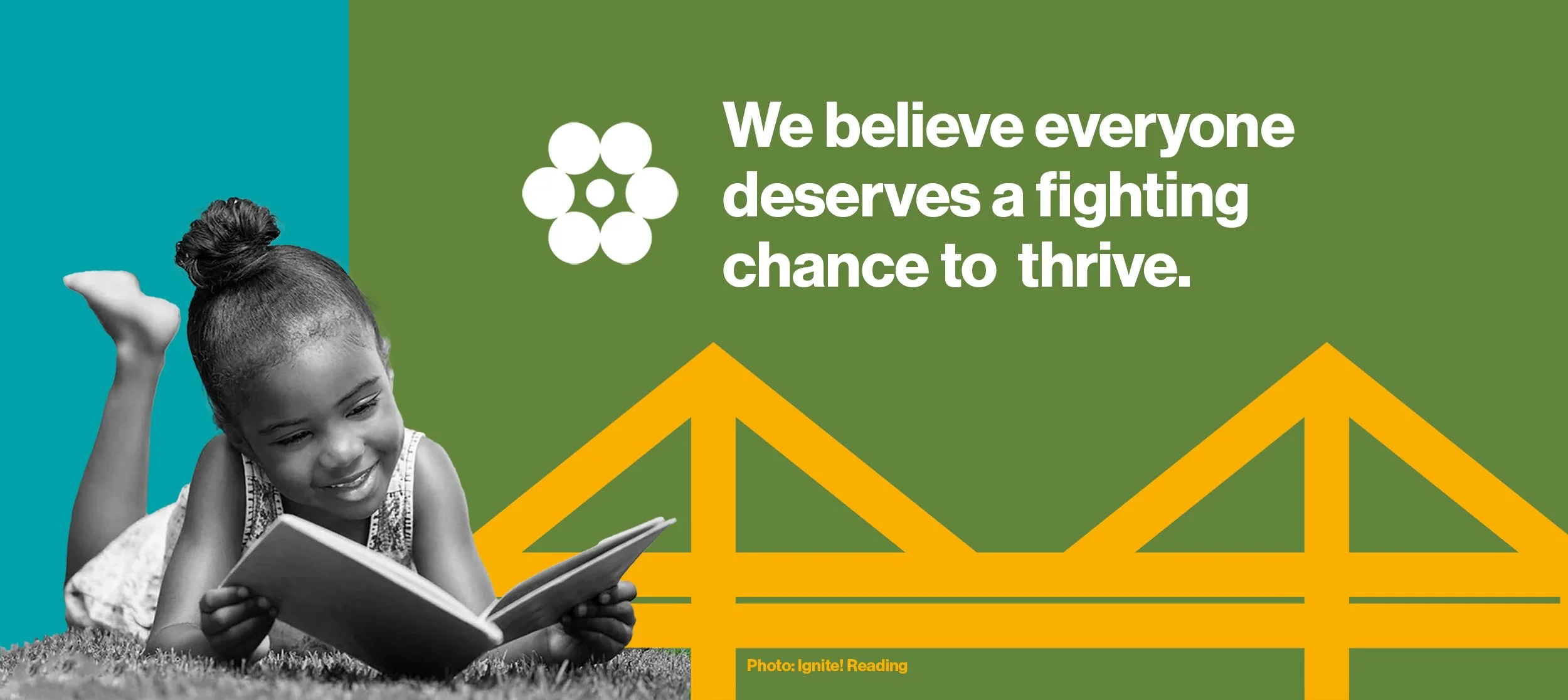 A young girl lies on grass as she reads a book. A bridge graphic features in the background with the words: We believe everyone deserves a fighting chance to thrive.