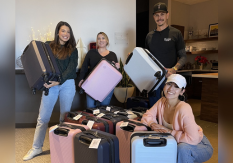 Team members with suitcase donations