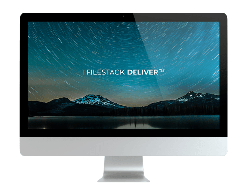 A computer monitor displays a night sky with star trails above snow-capped mountains and a lake, featuring the text FILESTACK DELIVER™ in the center.